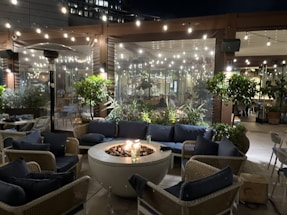 A cozy outdoor seating area at dusk with soft lighting and a small fire pit.