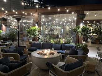 A cozy outdoor seating area with a fire pit and cushions.
