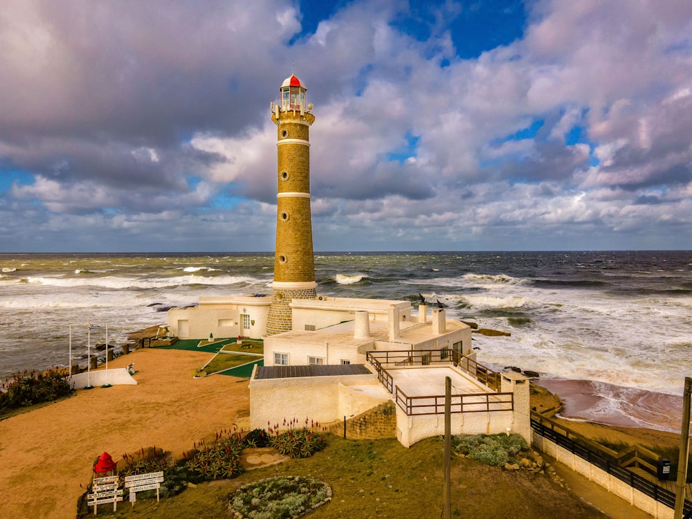 a lighthouse on a hill by the ocean