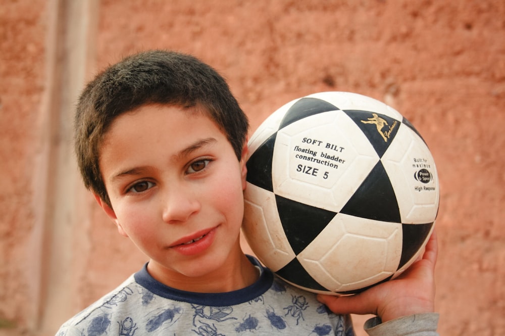 a boy holding a football ball
