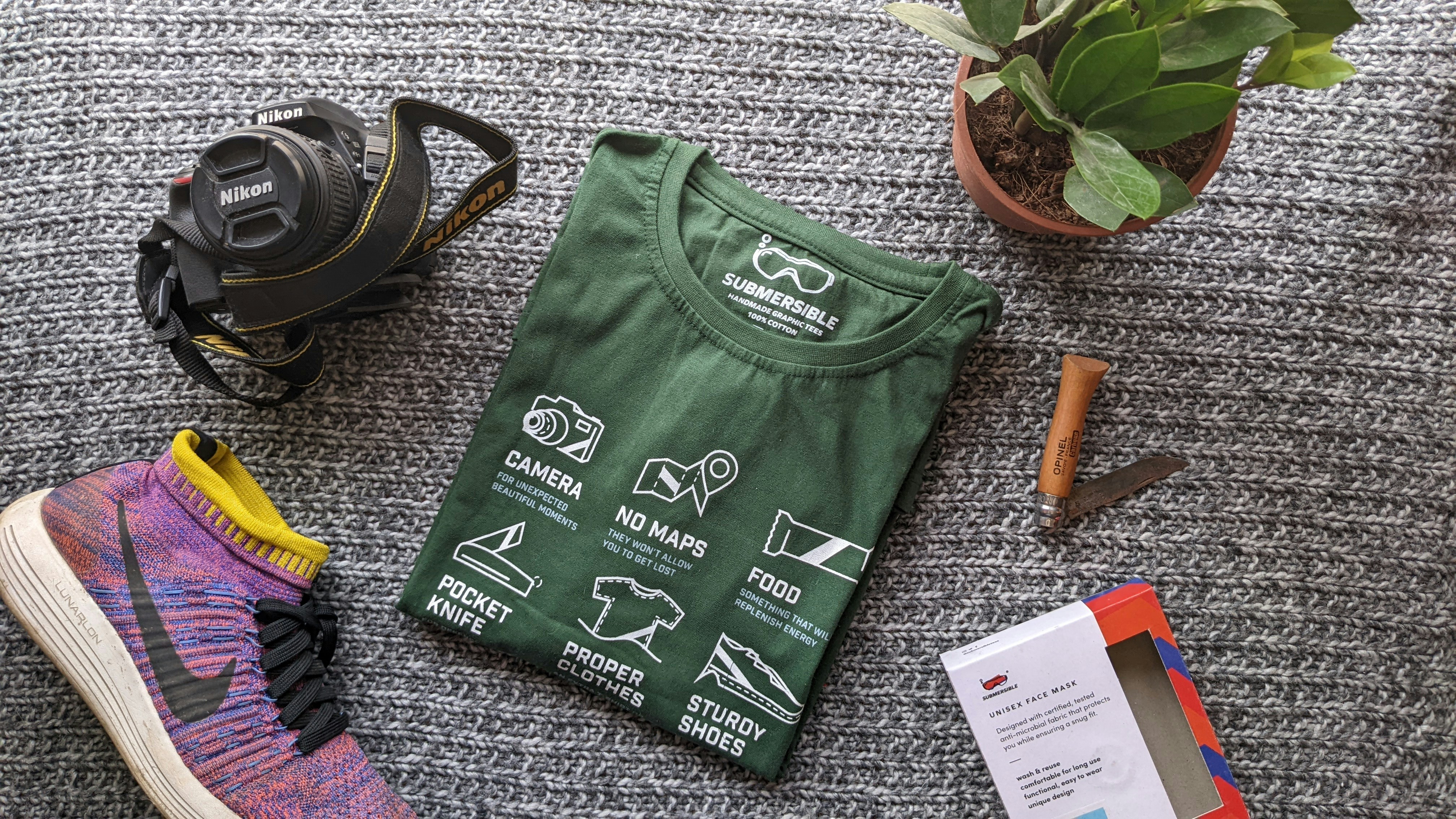 a green bag with a black bag and a pair of shoes