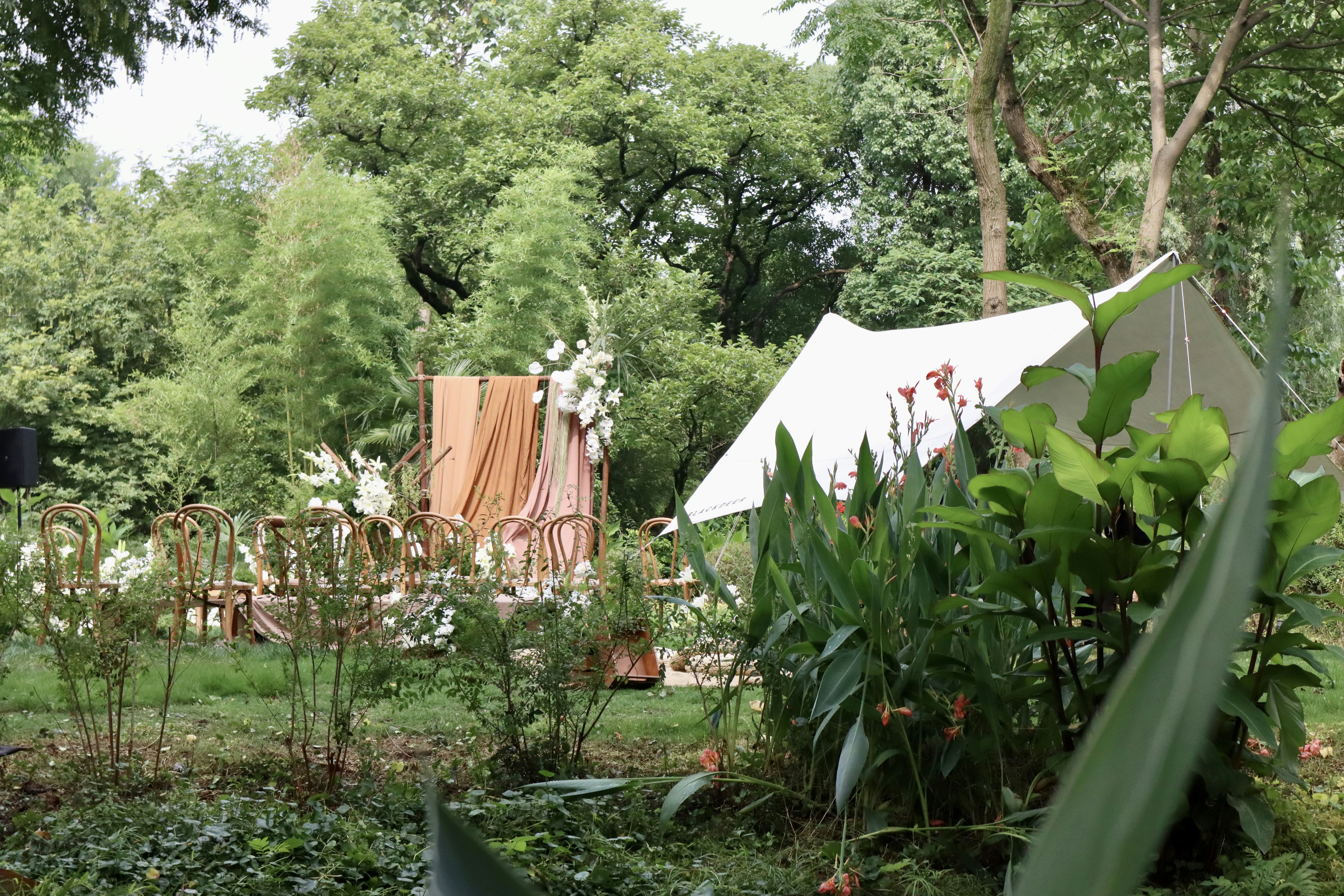a garden with a white tent
