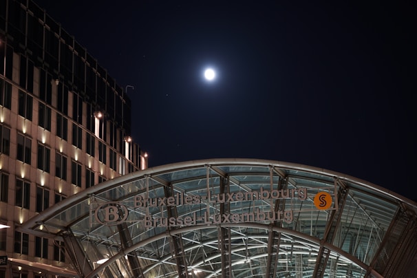 Cinematic shot of sleek glass buildings in Brussels' European quarter under a soft morning light.