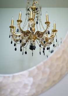 An elegant black and gold chandelier hanging above a stylish dining table