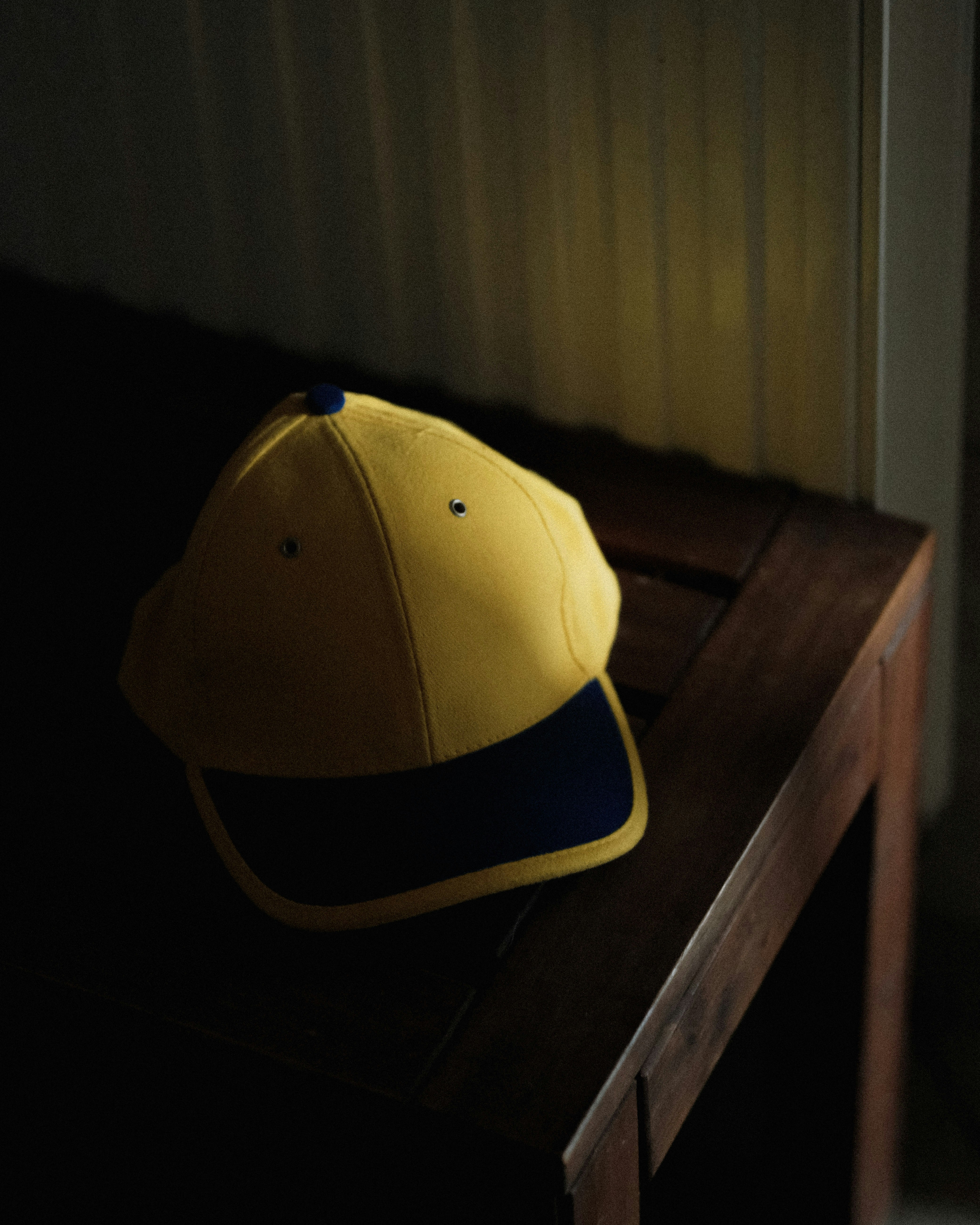 Traditional embroidered Hausa cap placed on a wooden surface, rich pattern detail, warm lighting