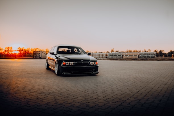 A sleek executive van parked in a modern urban setting at sunset.