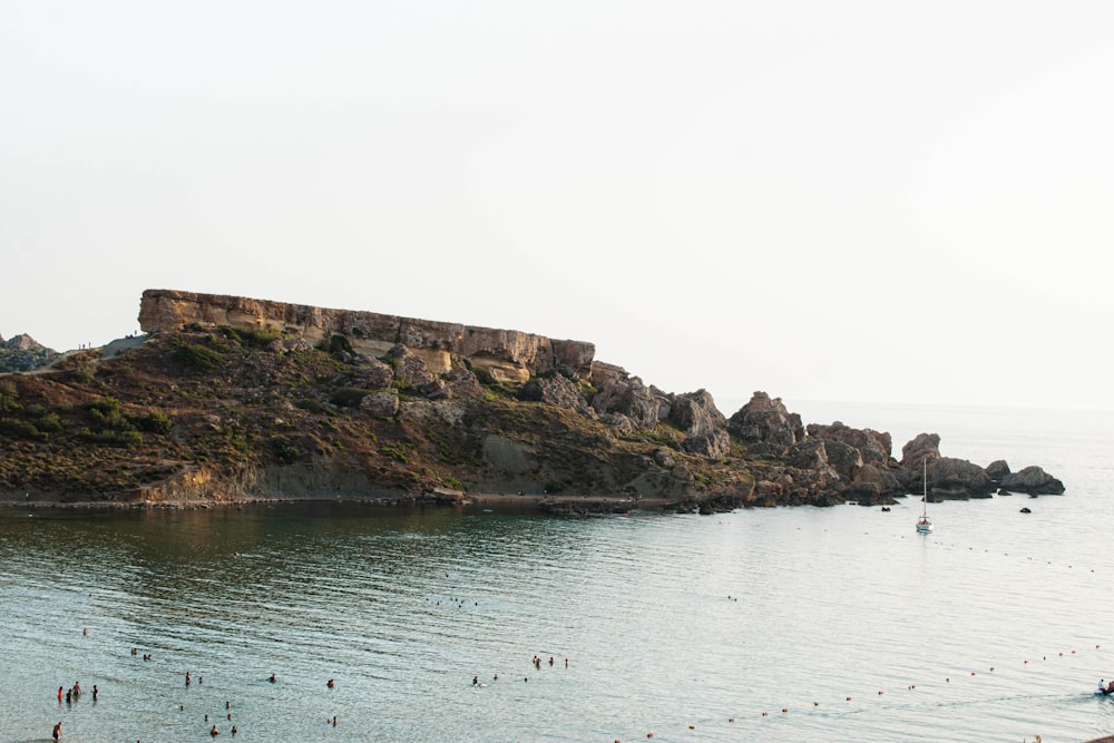 a rocky cliff with a body of water below