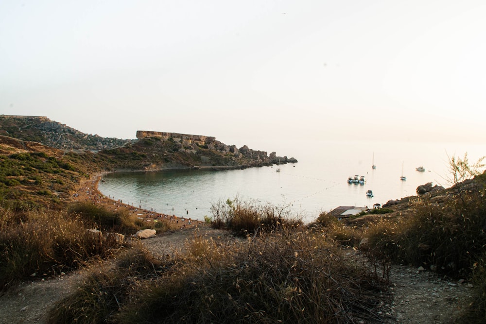 a body of water with boats in it and a hill with a building on it