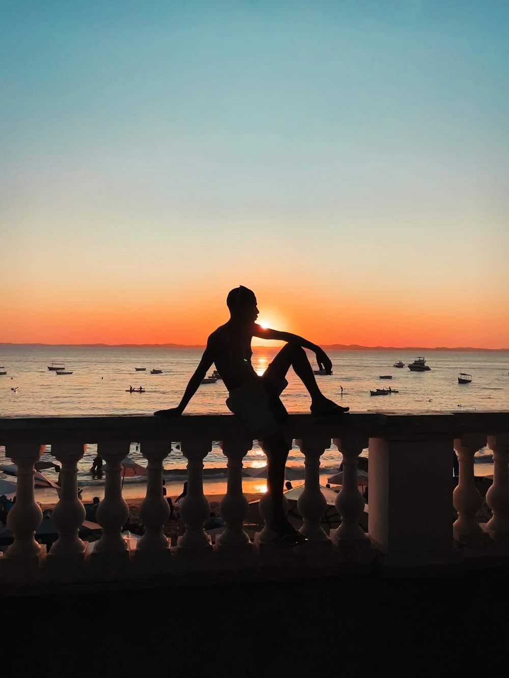 Eine Person, die auf einer Bank sitzt und den Sonnenuntergang betrachtet