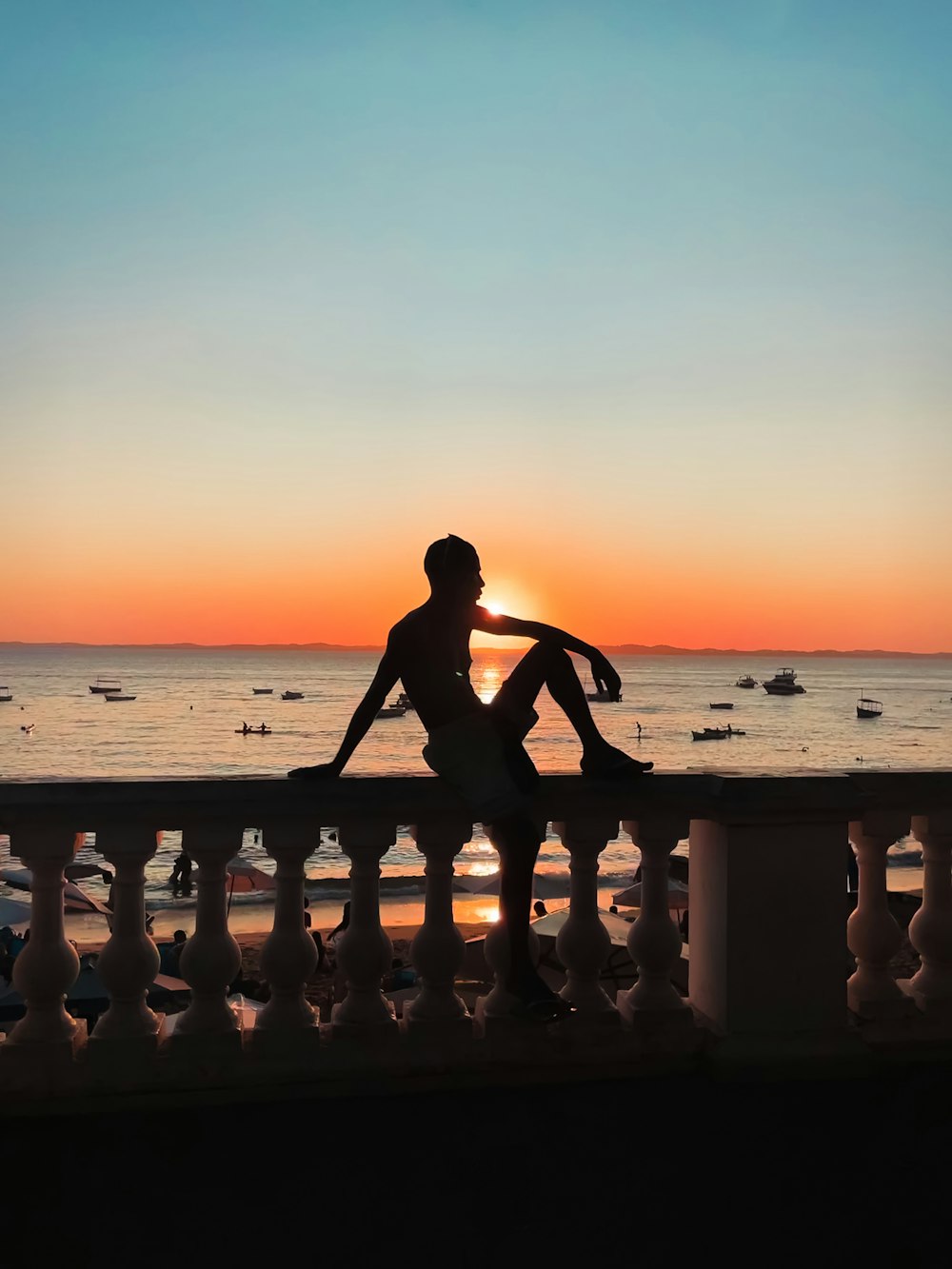 a person sitting on a bench looking at the sunset