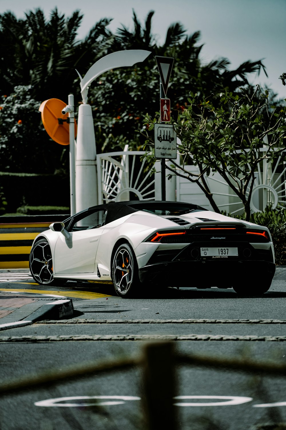 a white sports car parked on the side of a road