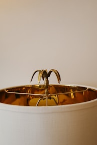 Close-up of a shiny brass lamp resting on a sleek mid-century modern table.
