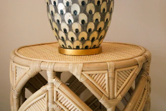 Close-up of a colorful 3D printed decorative vase with intricate geometric patterns on a wooden table.