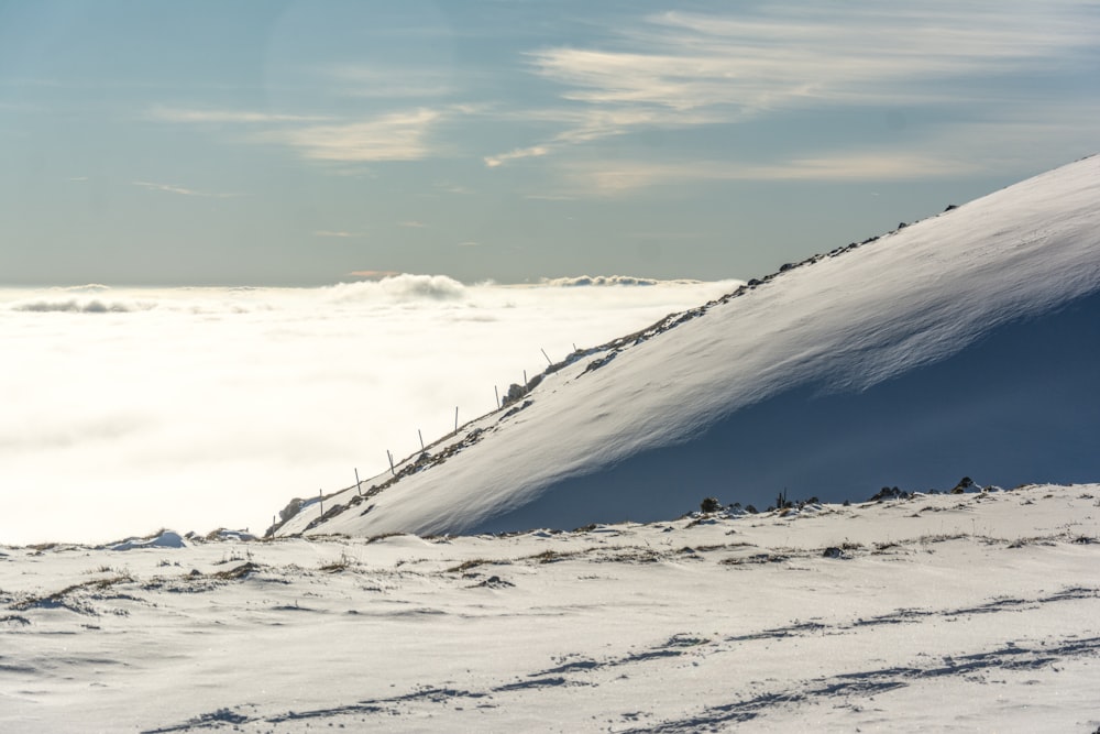 a snowy mountain with a fence