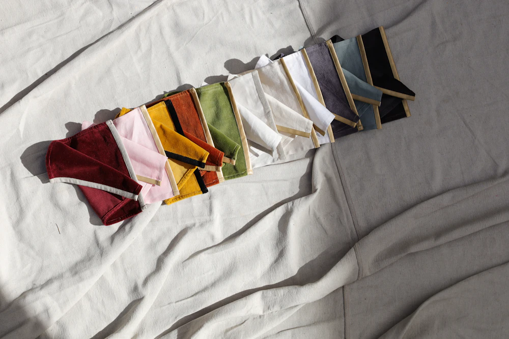 Several pairs of folded underwear in different colours laid out on a bed