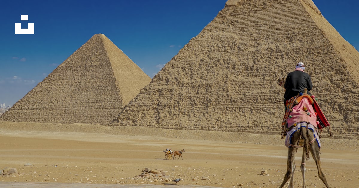 Une personne chevauchant un chameau devant une pyramide photo – Photo ...