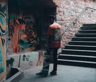 A complete skateboard setup resting against a graffiti-covered urban wall.
