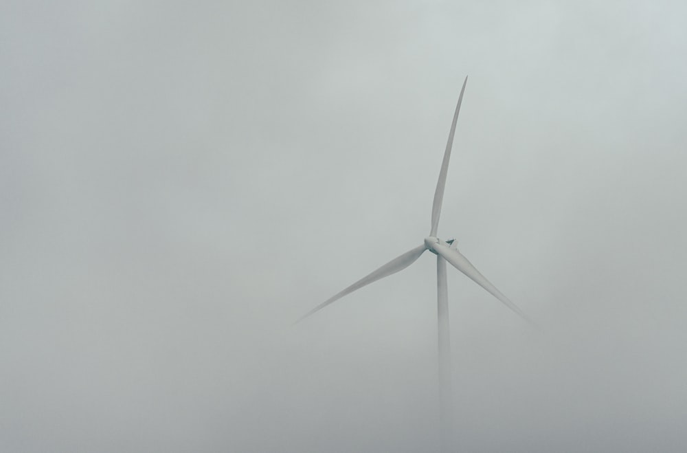 a wind turbine in the middle of a grey sky