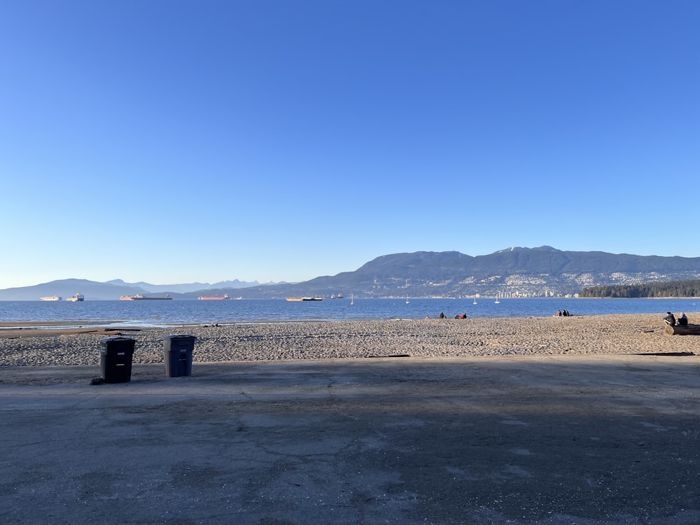 a beach with a body of water and mountains in the background