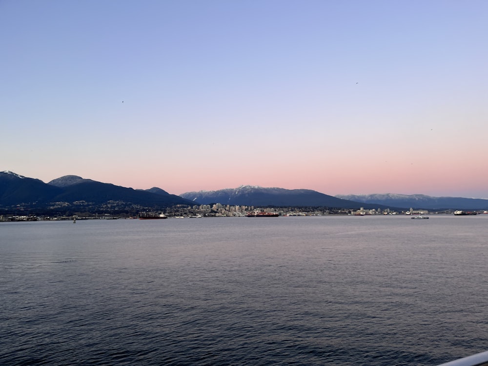 a body of water with mountains in the background