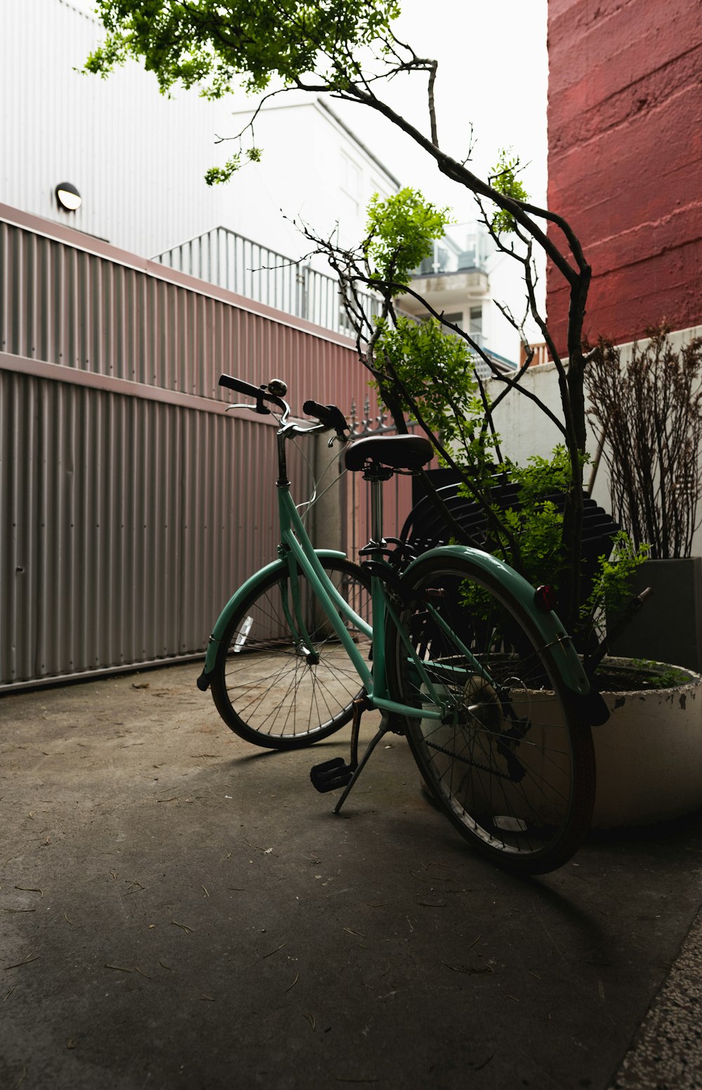 a green bicycle parked on a sidewalk