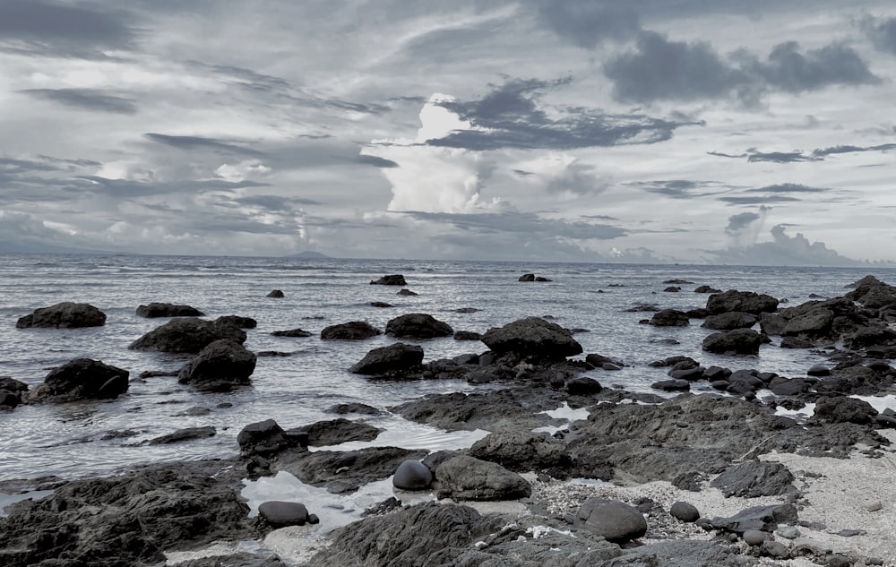 a rocky beach with a cloudy sky