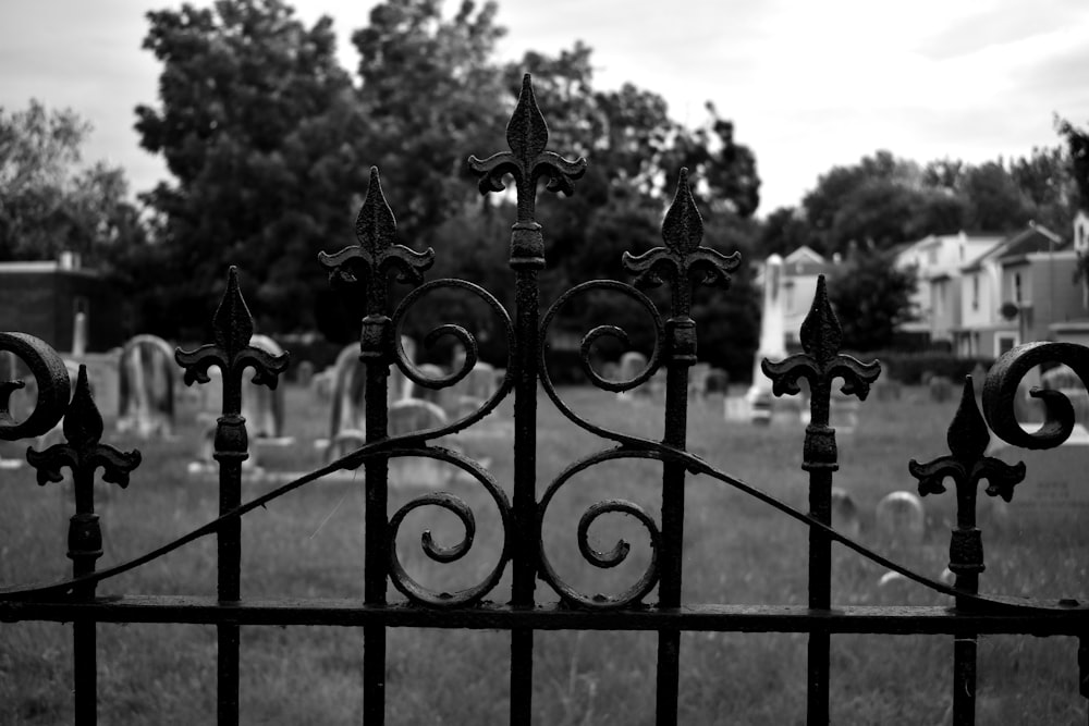 a black and white photo of a gate with a sign on it