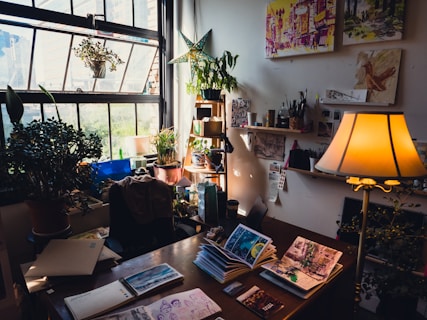 a desk with books and a lamp