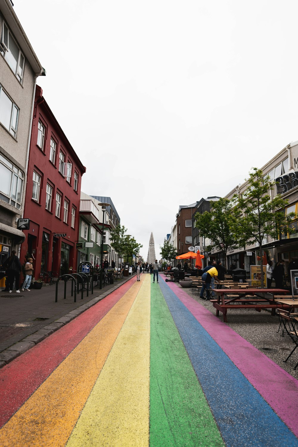 uma área pavimentada colorida com mesas e cadeiras e edifícios