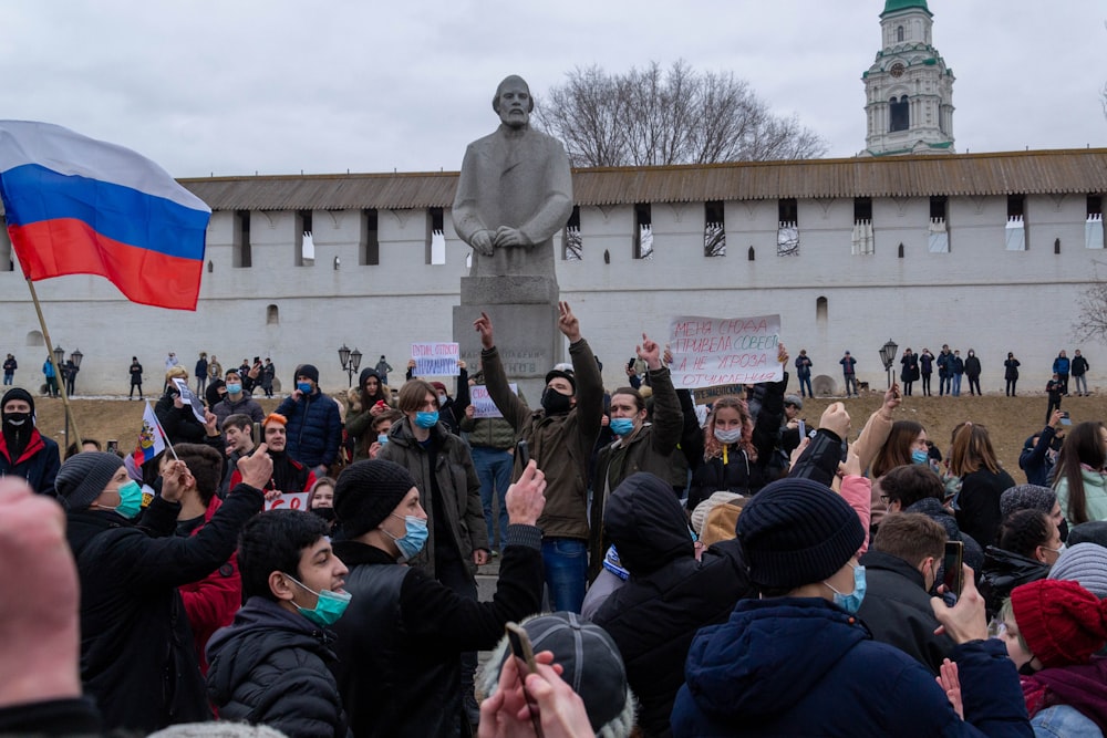 a crowd of people in front of a statue