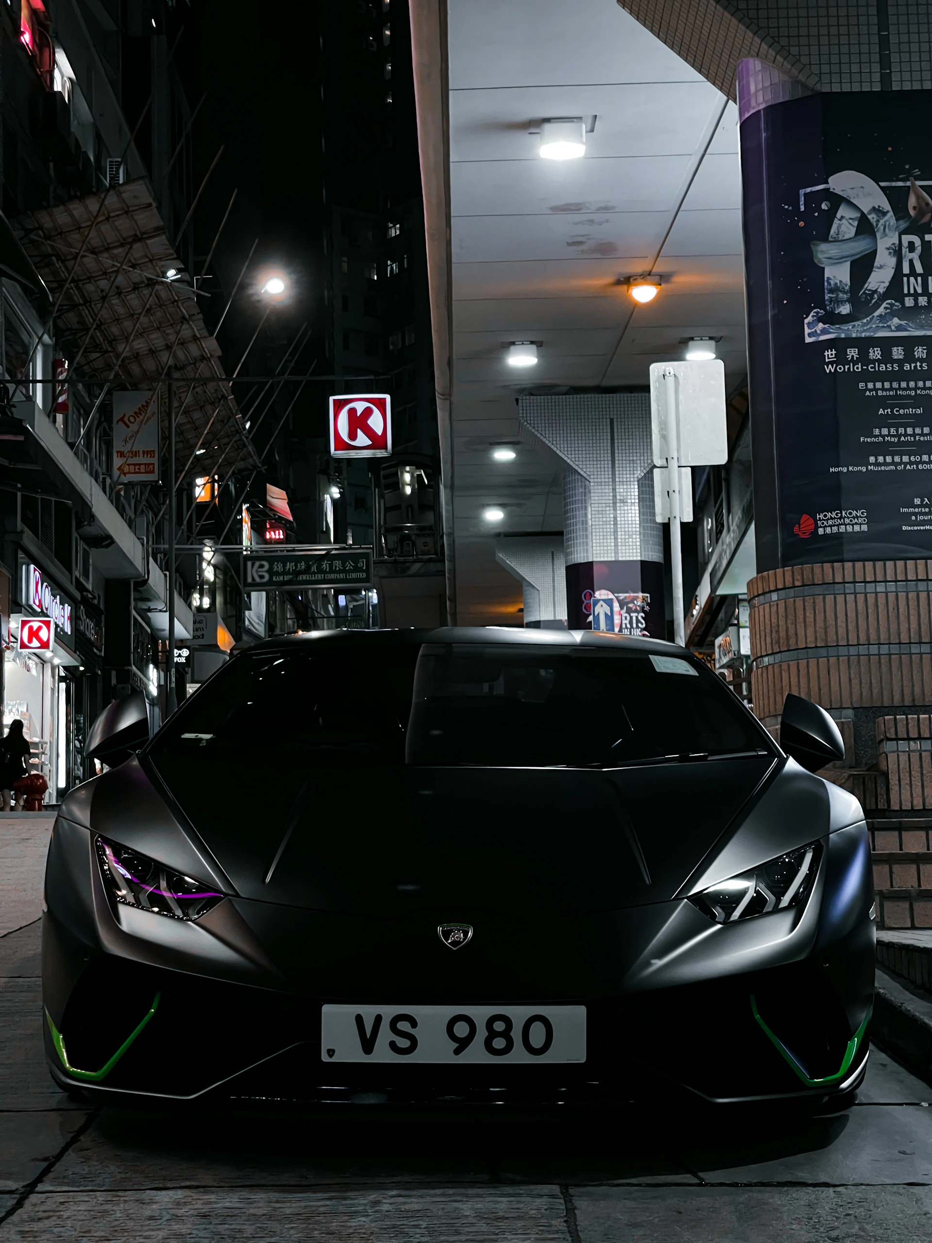A sleek black Lamborghini Aventador parked under soft city lights with a subtle Gaussian blur background enhancing its sharp lines.