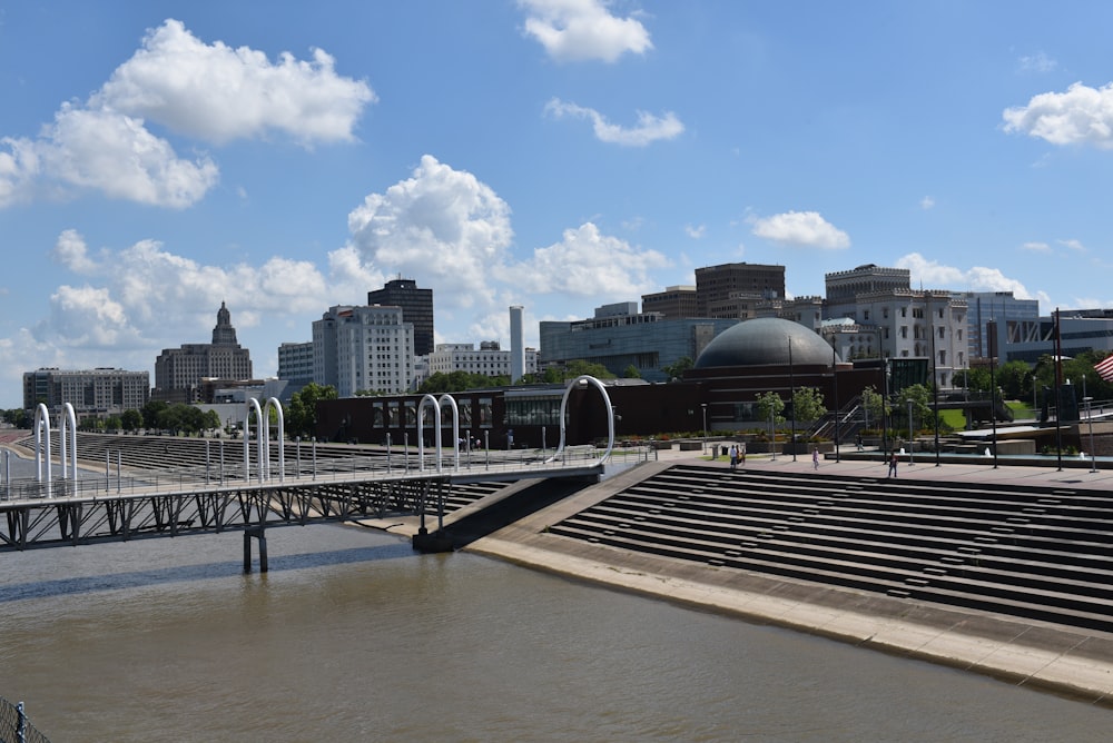 a bridge over a river with a city in the background