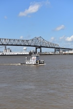 a boat sailing under a bridge