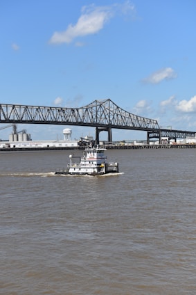 a boat sailing under a bridge