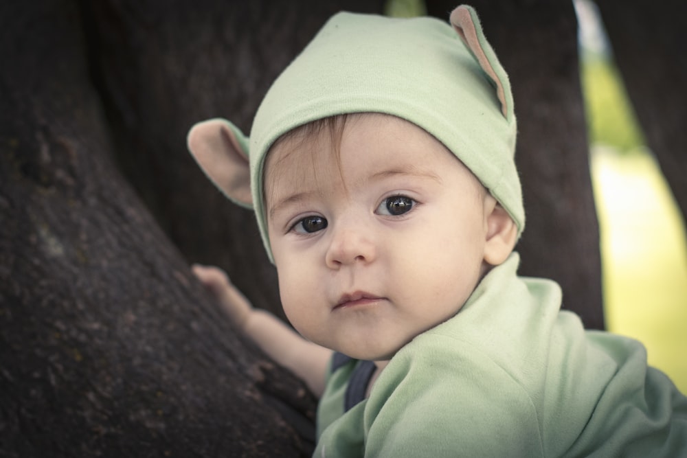 a baby wearing a green hoodie