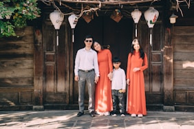 a group of people posing for a photo in front of a wood door