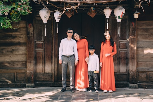 a group of people posing for a photo in front of a wood door