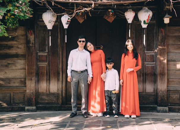 a group of people posing for a photo in front of a wood door