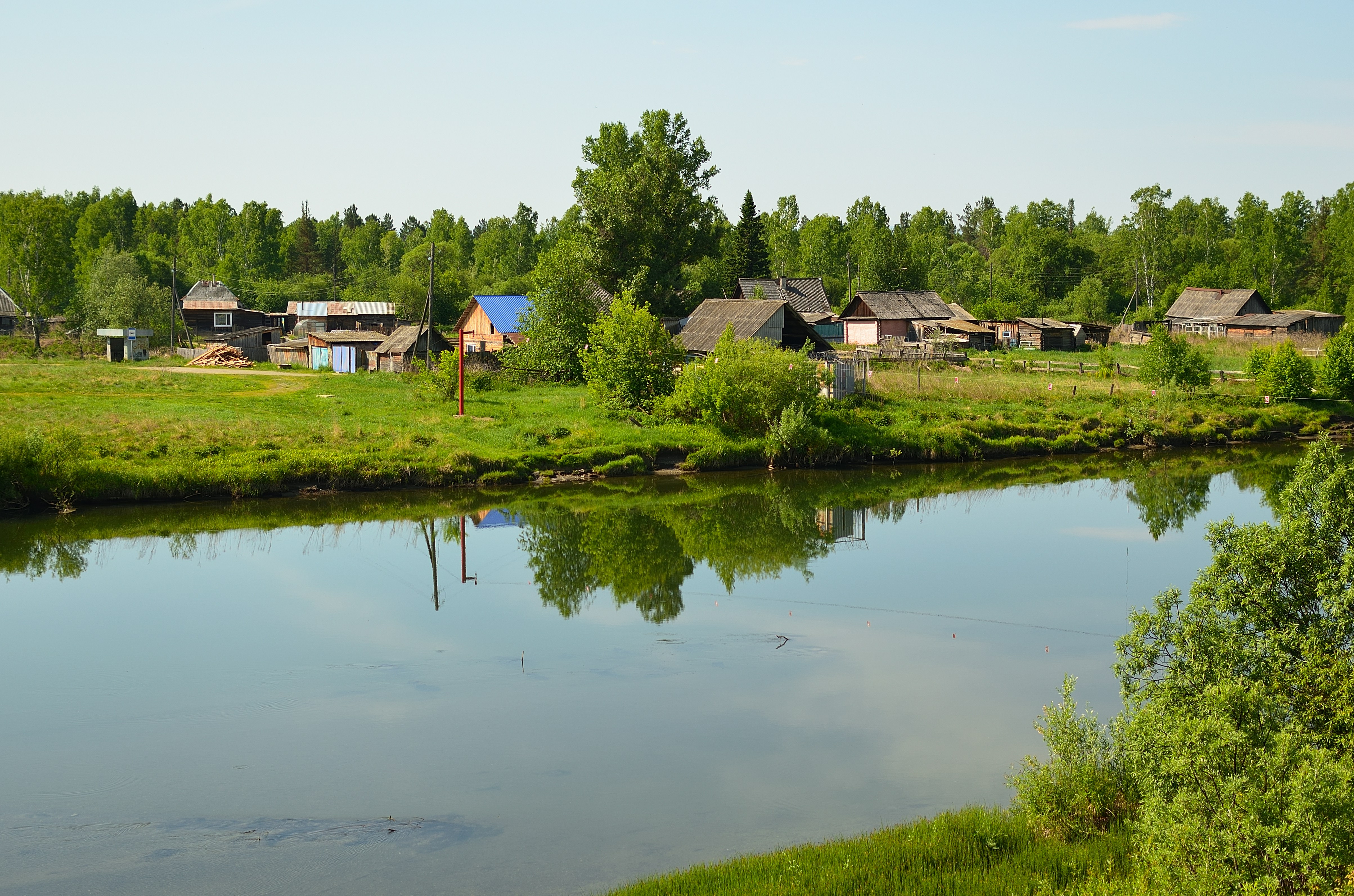 a body of water with houses and trees around it