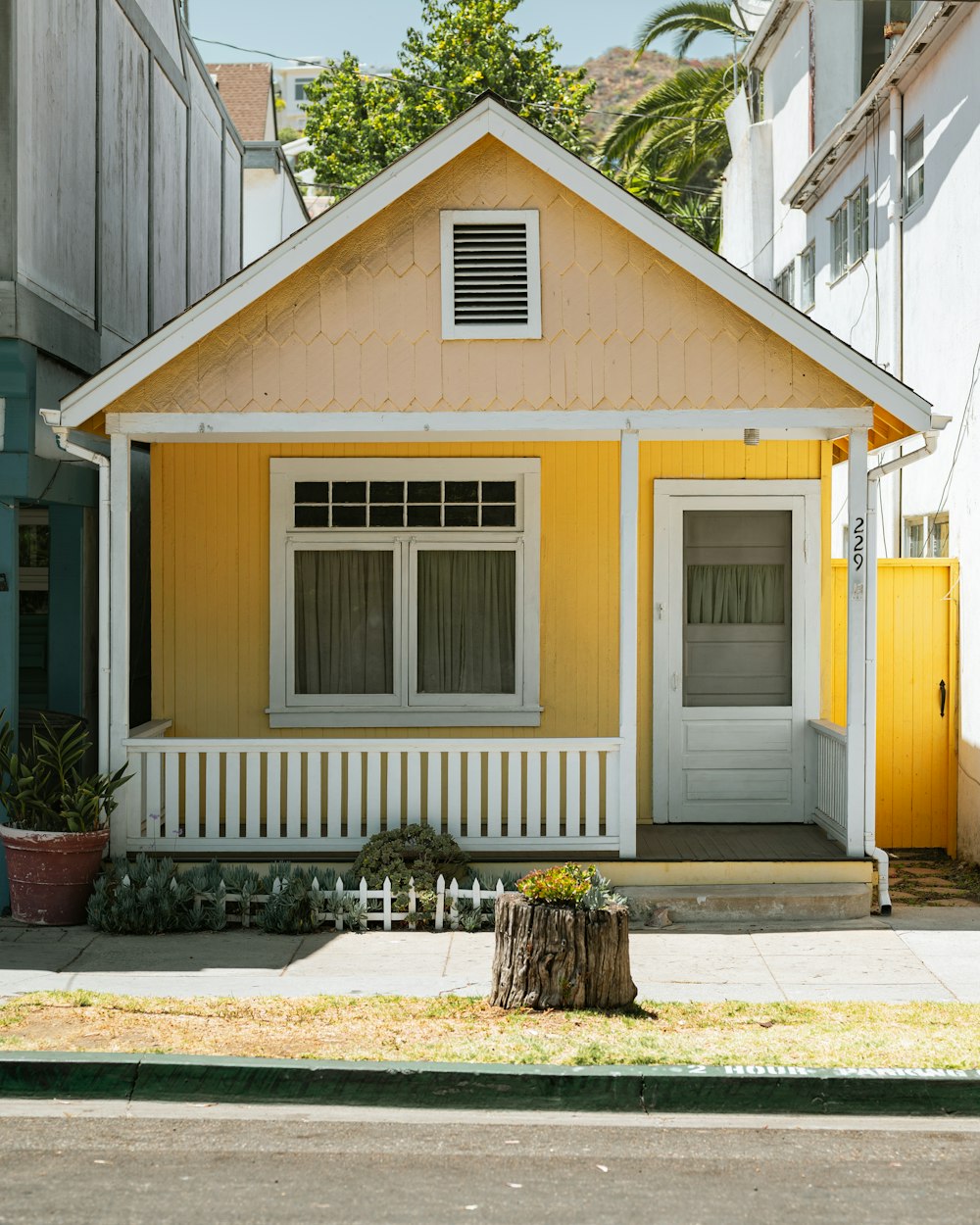 a yellow house with a white fence