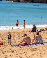 A family enjoying a beachcomber quest with a QR code on a sunny shore.