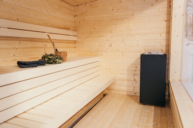 Handcrafted wooden bench and shelves inside a traditional sauna setting.