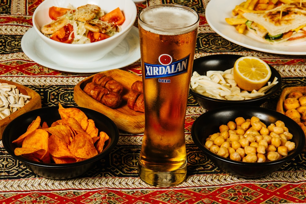 a table with plates of food and a glass of beer