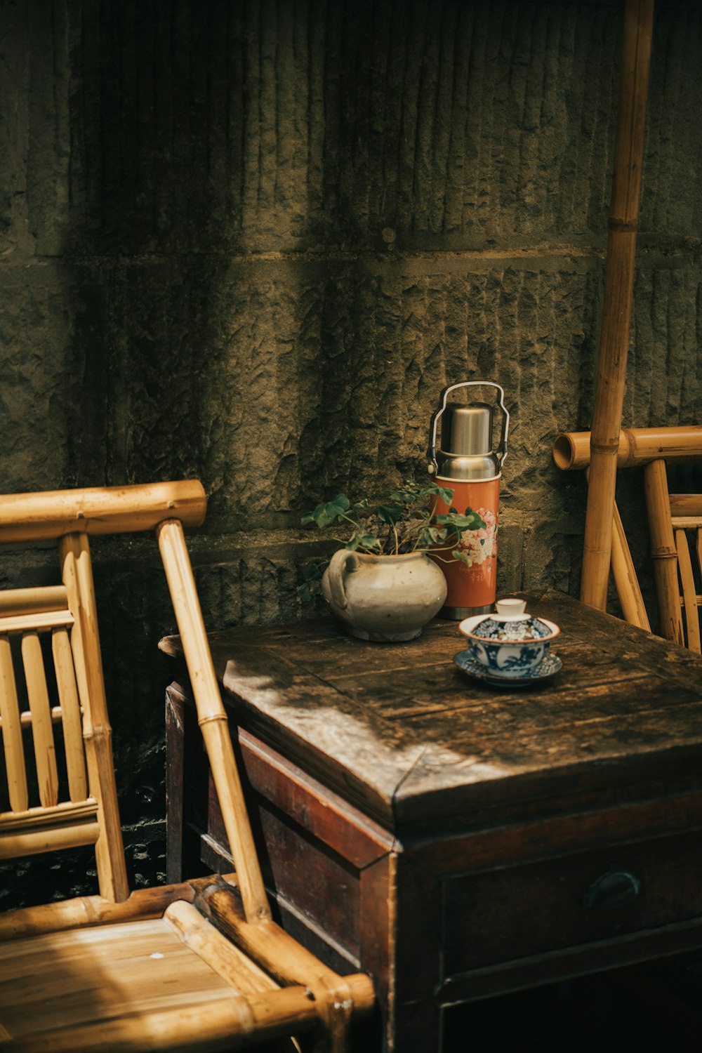 a table with a vase and potted plants on it