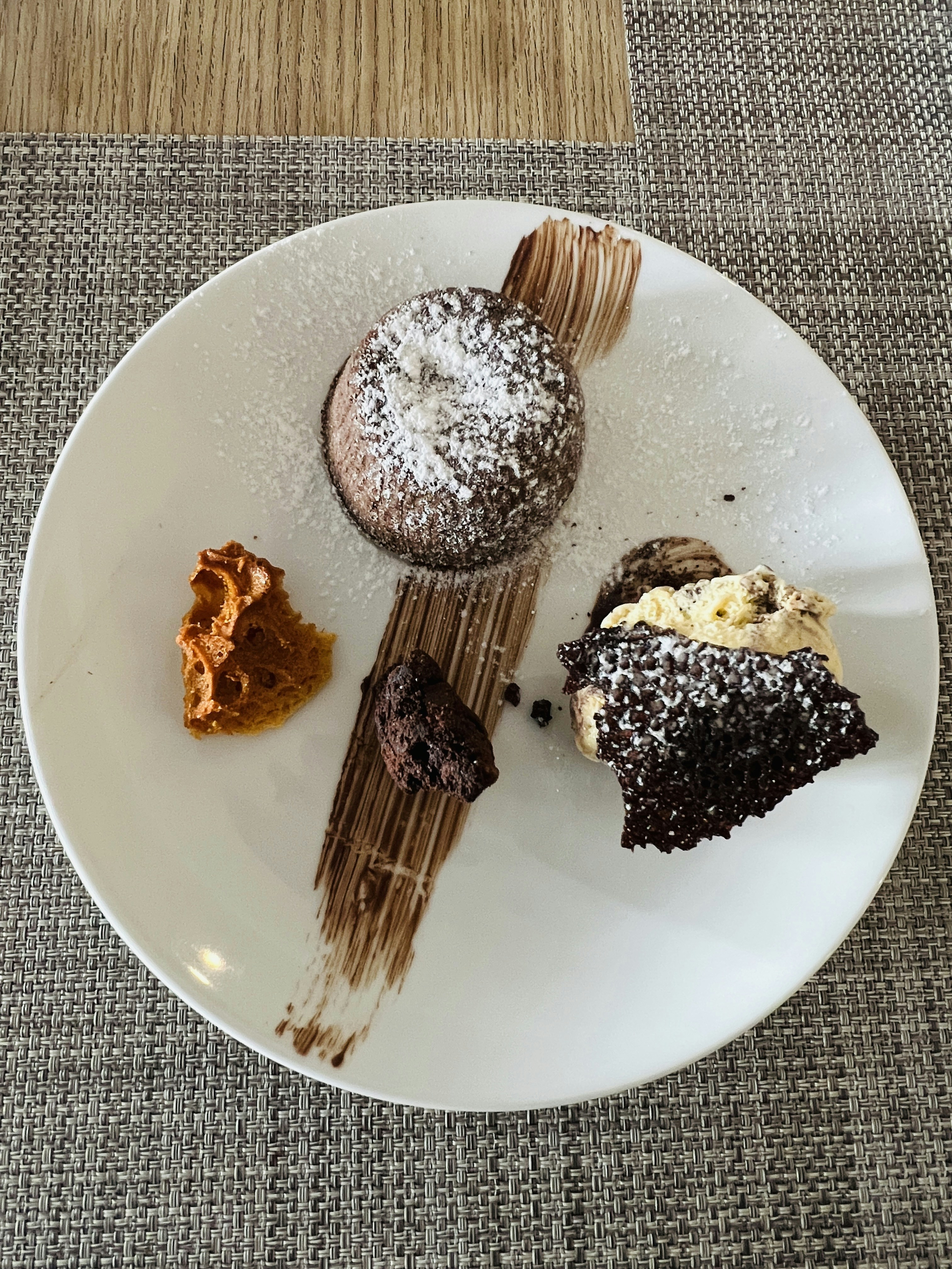 Warm molten chocolate lava cake with melted chocolate center and powdered sugar on white plate