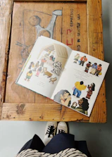 Colorful children’s storybook open on a wooden table with crayons.