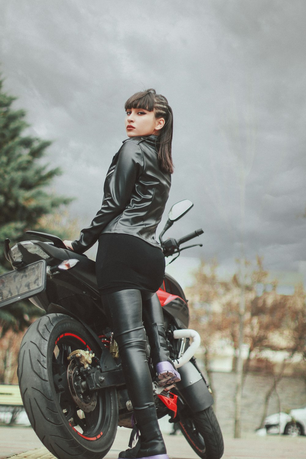 a man in black leather jacket sitting on a motorcycle