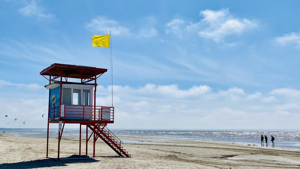 a small red structure on a beach