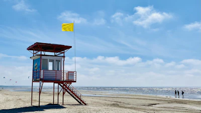 A red lifeguard tower on the wide sand of Pärnu beach