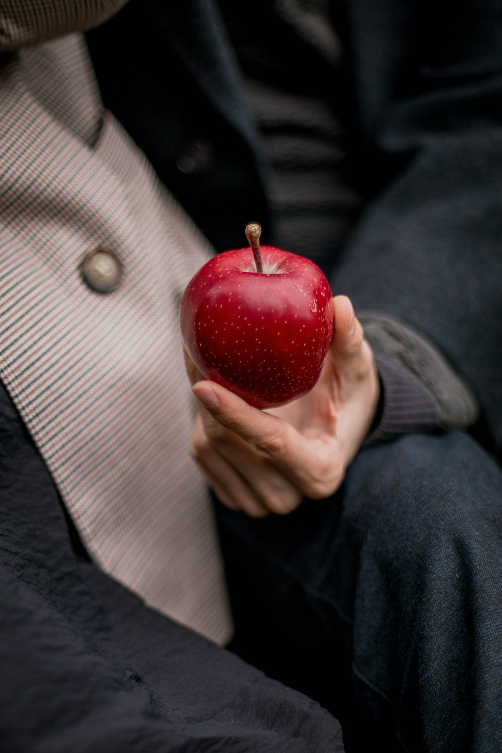 a person holding a red apple
